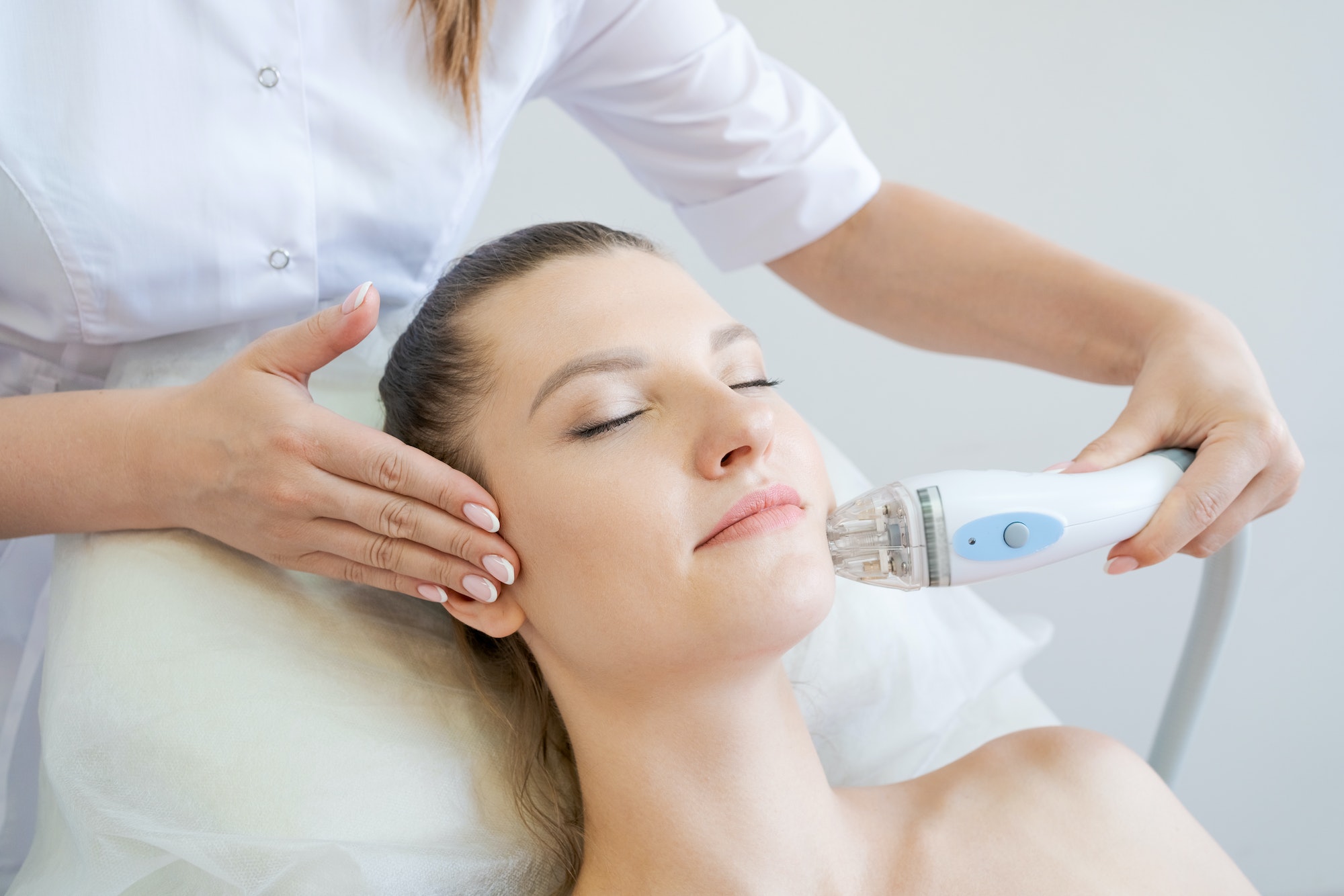 Handle radio frequency apparatus on chin woman's face during skin rejuvenation